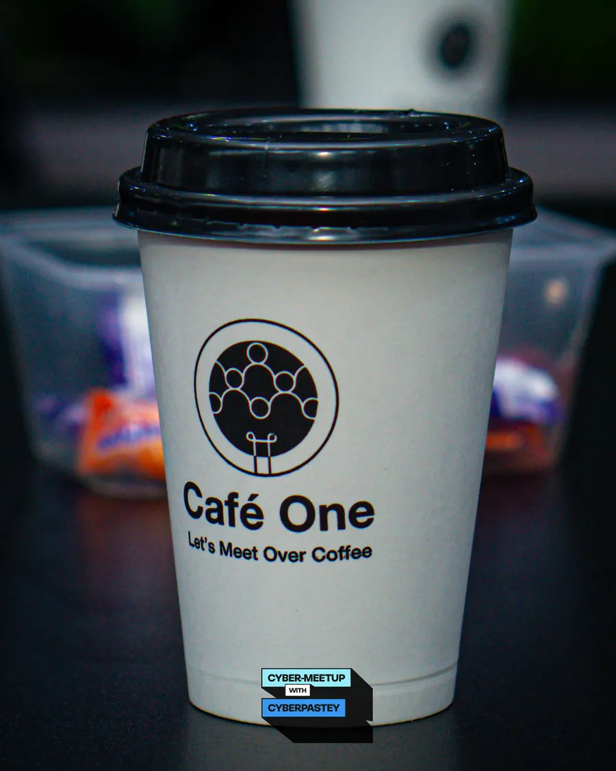 A Café One coffee cup photographed at the inaugural Cyber Meetup
