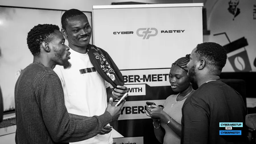 Cyber Meetup attendees networking in front of the event display